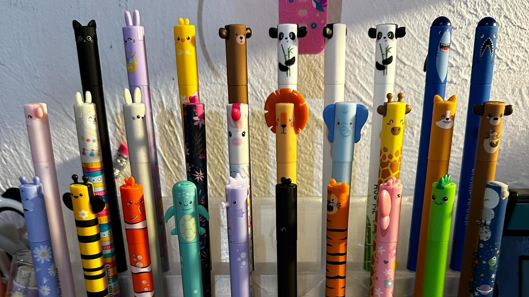 Plusieurs stylos Legami effaçables de couleurs différentes posés sur un cahier ouvert