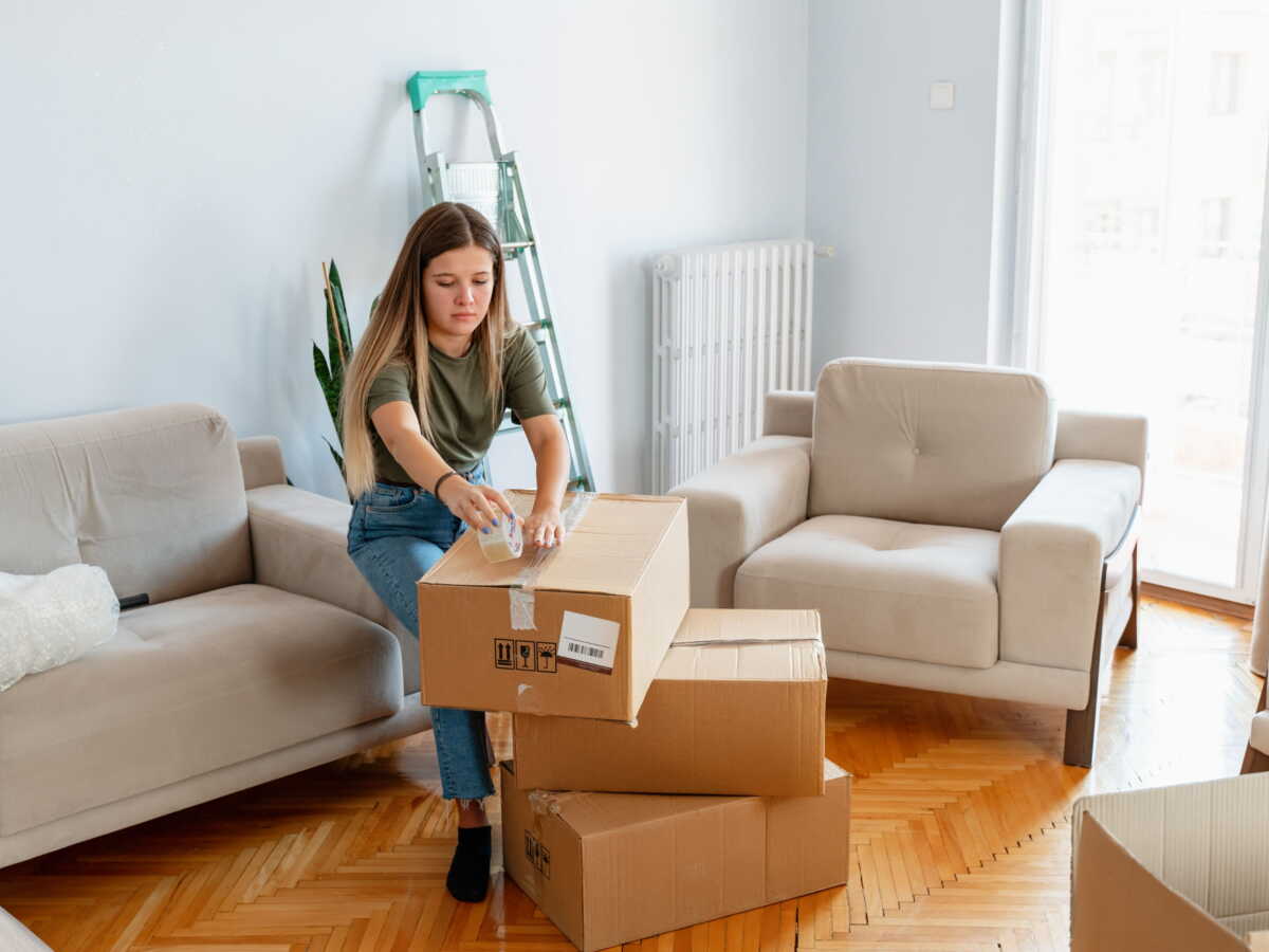 Jeune alternant signant son bail dans un petit appartement meublé près de son entreprise